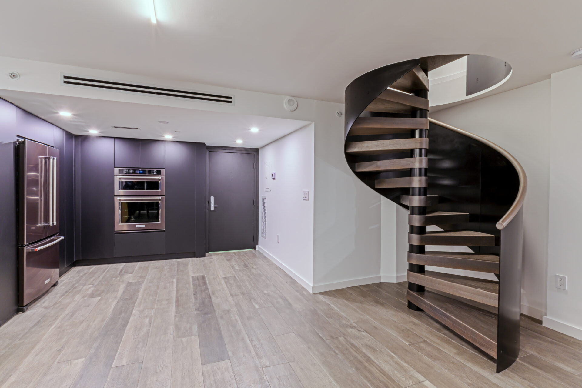A kitchen with a spiral wooden staircase